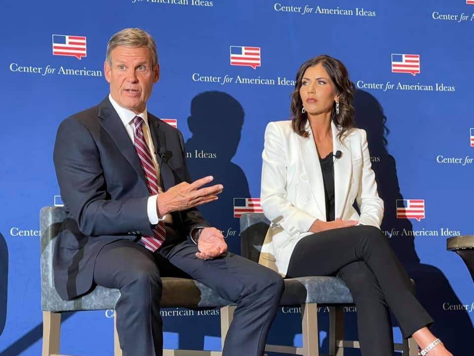 Photo of Governor Bill Lee (Tennessee) and Governor Kristi Noem (South Dakota) speak at a Center for American Ideas event in 2021.
